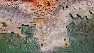תמונת מזל"ט עדכנית (2022) המציגה נזק למבנים ארכיאולוגיים בנמל העתיק של אפולוניה (מזרח לוב) שנגרם משחיקת החוף
