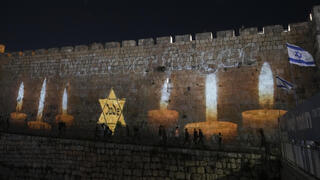 נרות זיכרון מוקרנים על חומות העיר העתיקה בירושלים