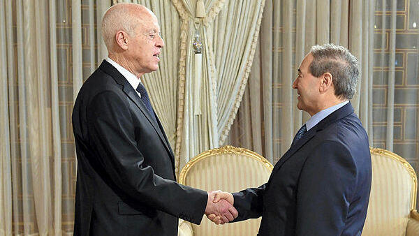 Tunisia's President Kais Saied (L) receiving Syrian Foreign Minister Faisal Mekdad