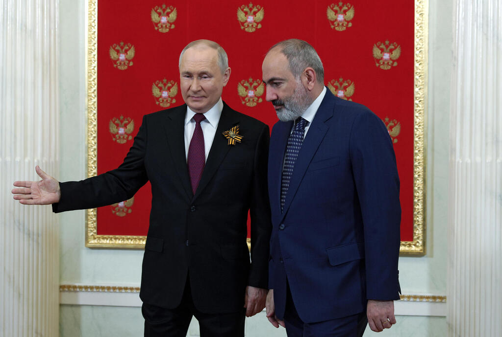 Russian President Vladimir Putin welcomes  Armenian Prime Minister Nikol Pashinyan before a Victory Day military parade 