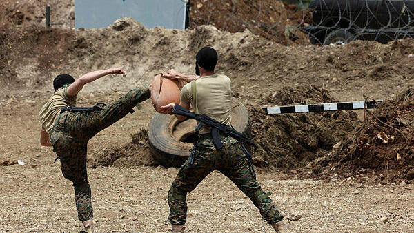 Lebanese Hezbollah fighters demonstrate military manuevers during a press tour in the southern Lebanese village of Aaramta, on May 21, 2023, ahead of the anniversary of the Israeli withdrawal from Lebanon