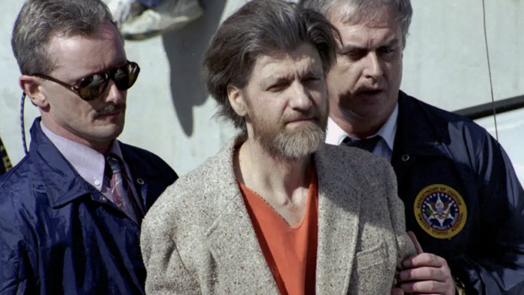 Theodore "Ted" Kaczynski is flanked by federal agents as he is led to a car from the federal courthouse in Helena, Mont., April 4, 1996 