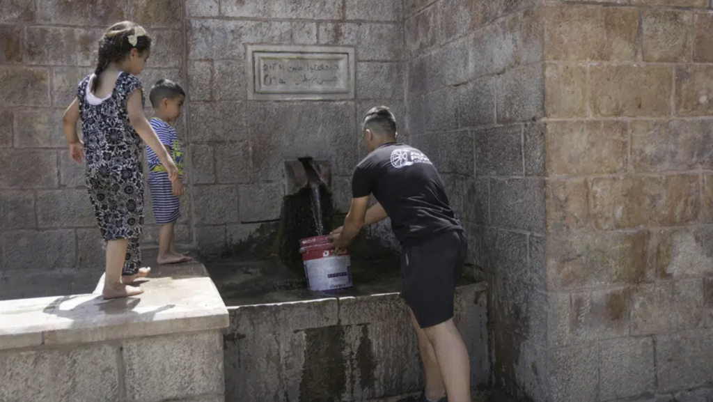 A Palestinian collects water from a spring in the West Bank village of Battir Sunday, June 4, 2023 