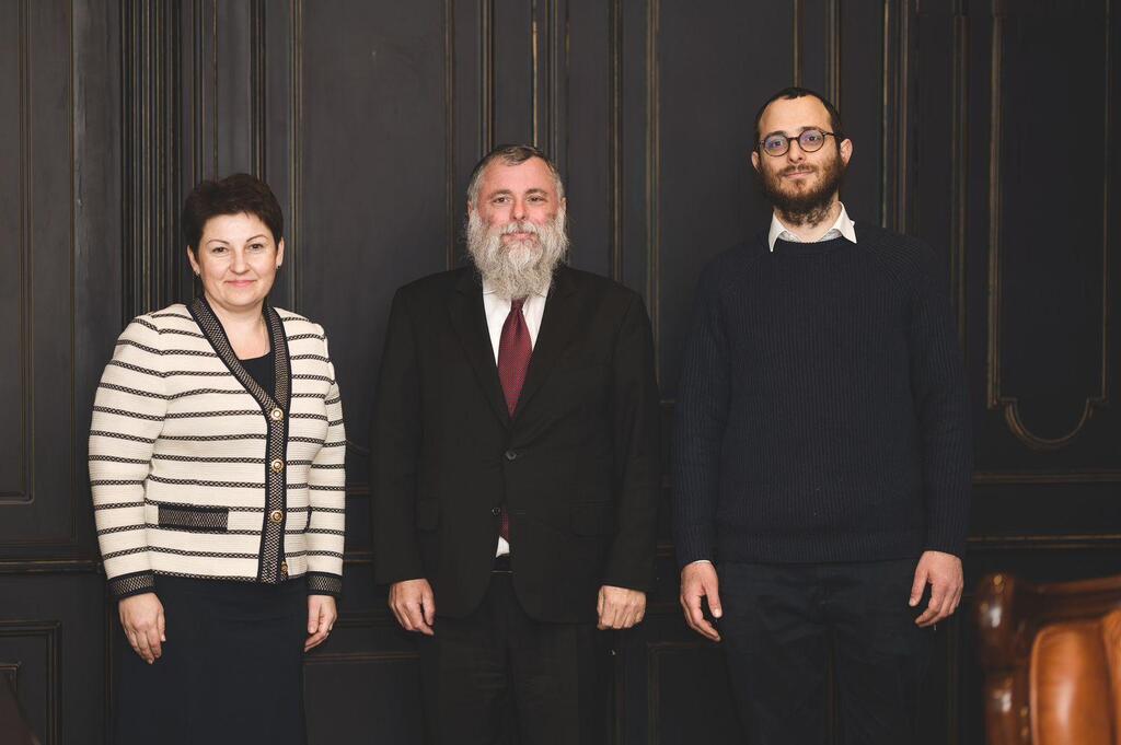 Rabbi Jonathan Markowitz (center) with his son a Ukrainian prison official 