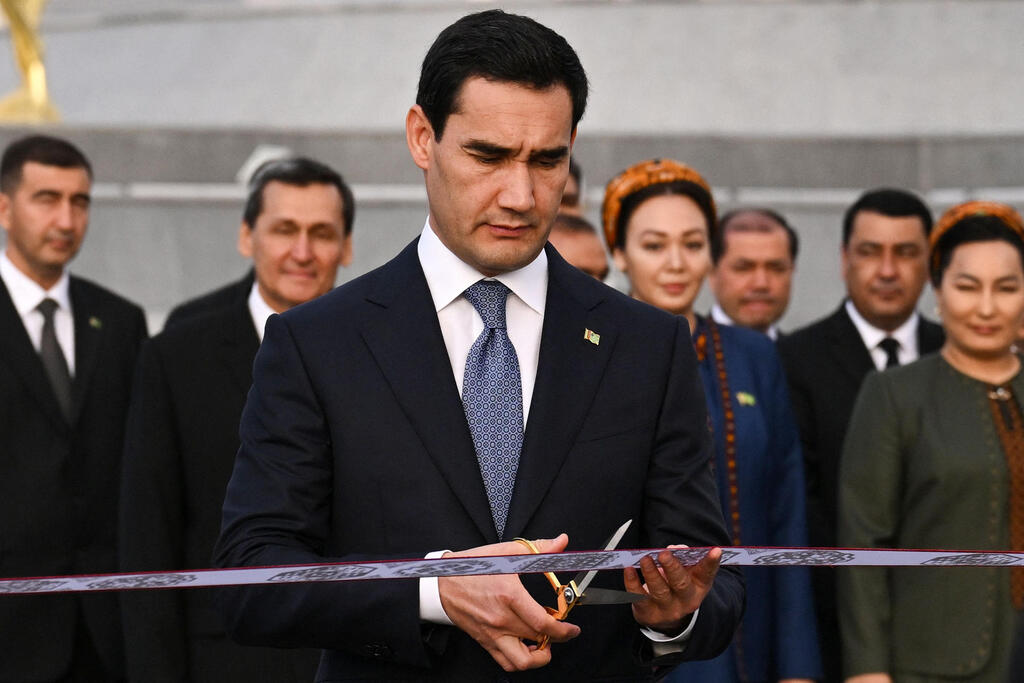 Serdar Berdimuhamedov cuts the ribbon at the ceremony (Photo: Natalia KOLESNIKOVA, AFP) נשיא טורקמניסטן סרדר ברדימוחמדוב חונך עיר ארקדג על שם אביו הרודן גורבנגולי ברדימוחמדוב