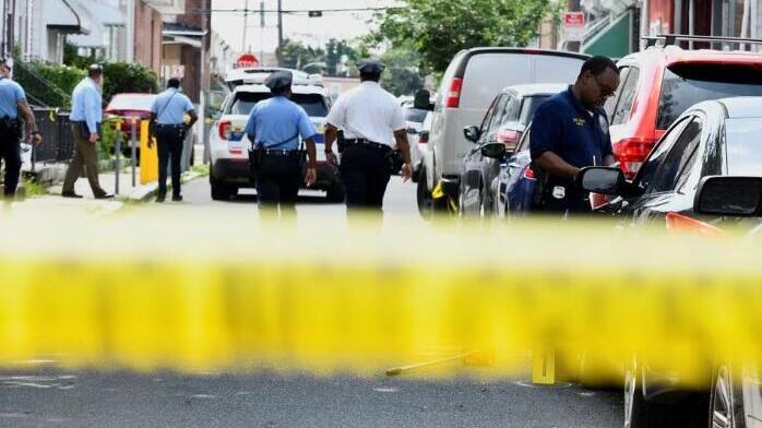 Police officers work at the scene as investigations are ongoing the day after a mass shooting in the Kingsessing section of southwest Philadelphia, Pennsylvania 