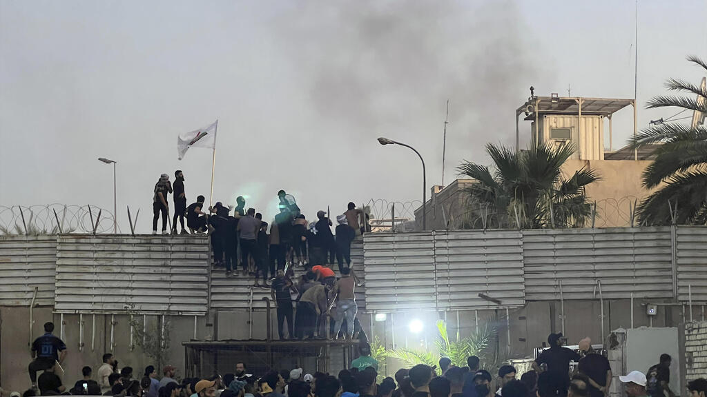 עיראק מפגינים מטפסים על חומות שגרירות שבדיה פריצה מחאה על שריפת קוראן