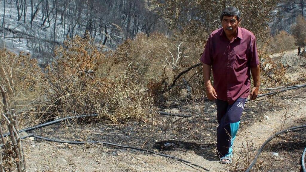 Izzadin Zuhaira, a Syrian farmer who said his farmhouse had already been damaged by years of war, then was further cracked by the February earthquake, and now ravaged along his orchard by wildfires 