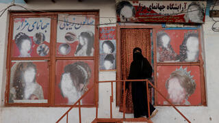 אפגניסטן טליבאן קאבול אישה יוצאת מ מכון יופי שתמונות נשים הושחתו בו מבחוץ ב שנת 2021
