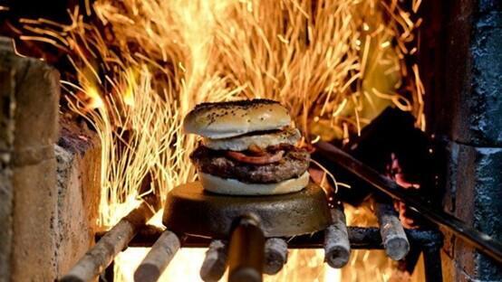 A hamburger cooked over an open flame