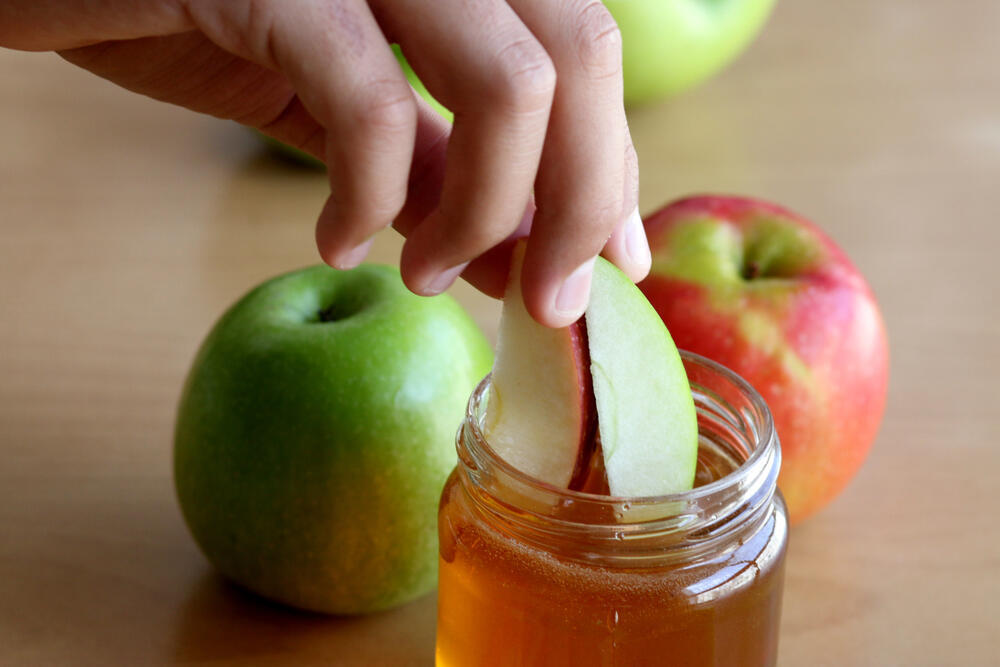Яблоки макают в мед и желают сладкого года