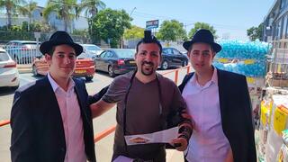 זורק הביצה מניח תפילין עם אנשי חב"ד בדוכן