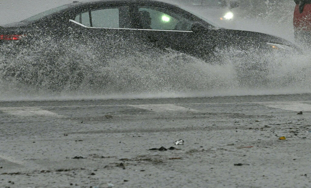 Vehicles splash up water during heavy rains from Hurricane Hilary, in south Los Angeles