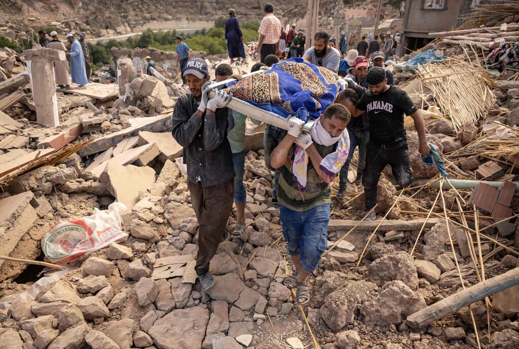 People carry the remains of the earthquake victim 