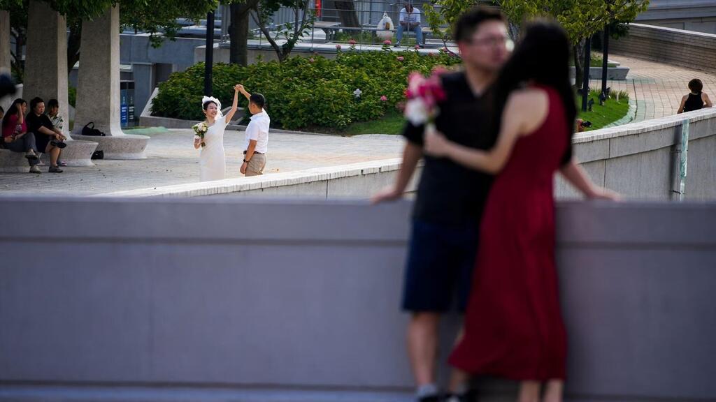 Couples prepare to get their photo taken during a wedding photography shoot 