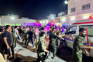 אמבולנסים וכוחות הצלה מחוץ לבית חולים מקומי אליו מפנים פצועים מהשריפה באולם האירועים בנינווה