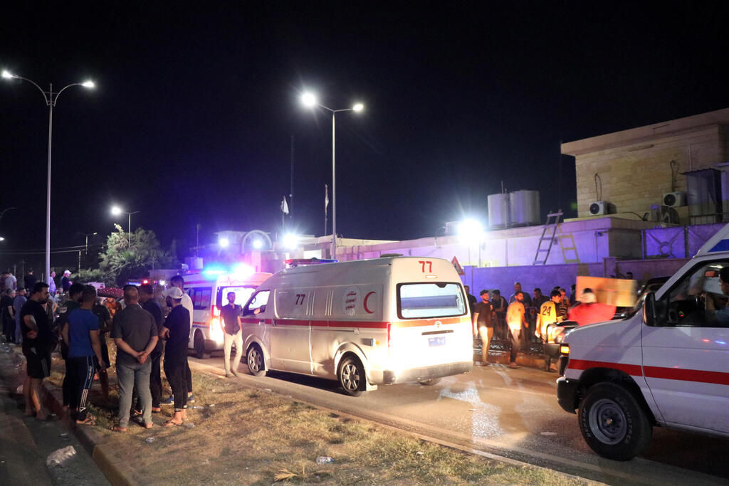 Ambulances carry wounded from the deadly wedding fire 