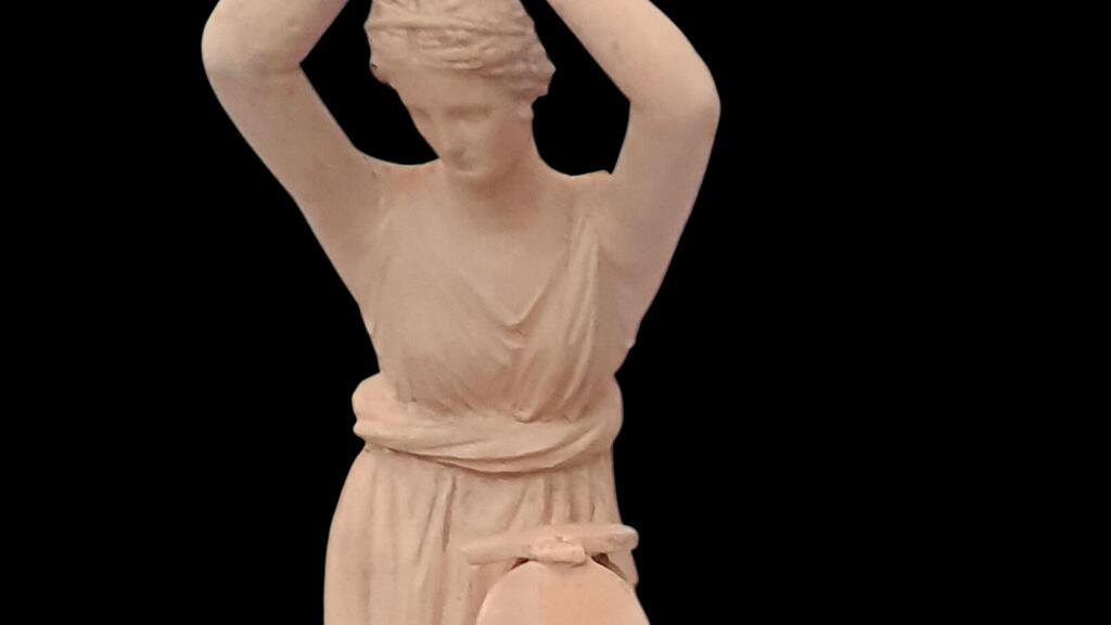 צלמית חרס הלניסטית של אישה מתבוננת במראה מתקפלת. מוצגת במוזיאון המטרופוליטן בניו יורק.