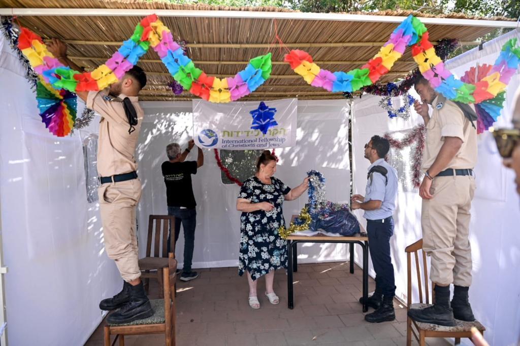 the International Fellowship of Christians and Jews Brings IDF to help construct sukkot in senior homes all across Israel