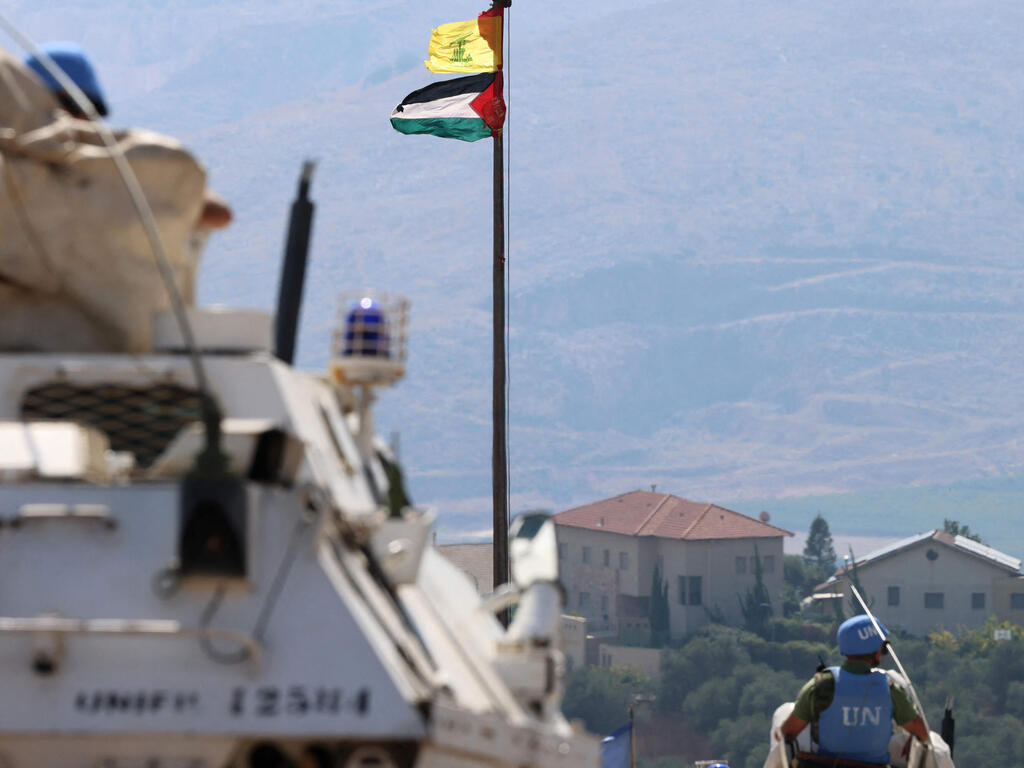 Патруль сил ООН и флаги Хизбаллы и ПА в Южном Ливане (Фото: Joseph EID / AFP) דגל פלסטין ו חיזבאללה ליד פקחי או"ם יוניפי"ל ב דרום לבנון