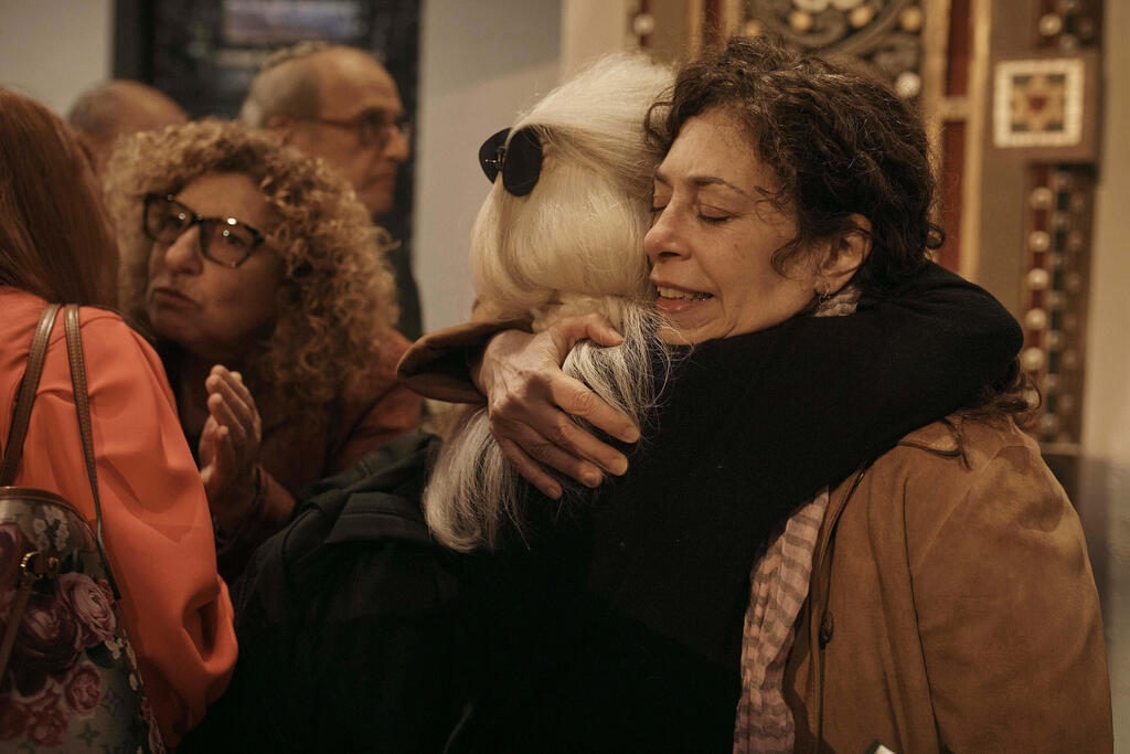Jews hug after a communal prayer to honor and offer support for the victims in Israel