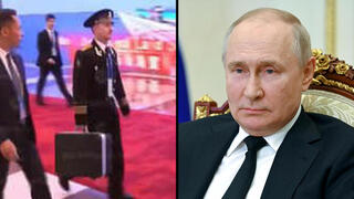קצינים מלווים את נשיא רוסיה ולדימיר פוטין ב סין עם ה תיקים ה גרעיניים