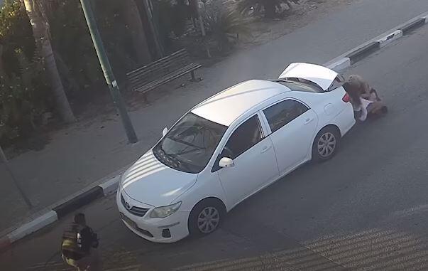 Image from the video: Women tried to hide behind their vehicle  