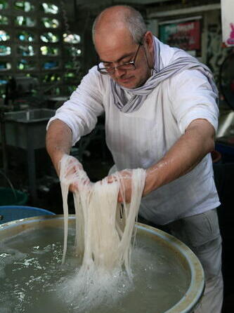 Анатолий Гендин промывает рисовую лапшу в Таиланде 