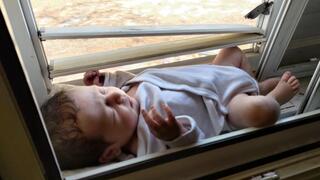 הבן קאי מונח על אדן החלון שעה לפני החילוץ 