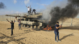 ארכיון מחבלים פלסטינים חוגגים על טנק עולה באש 
