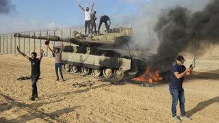 ארכיון מחבלים פלסטינים חוגגים על טנק עולה באש 