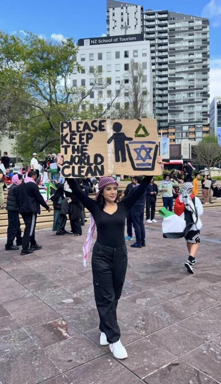 Woman holds antisemitic sign at pro-Palestinian rally 