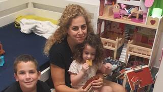 Dalit Ram Aharon sitting in a bomb shelter with her children  