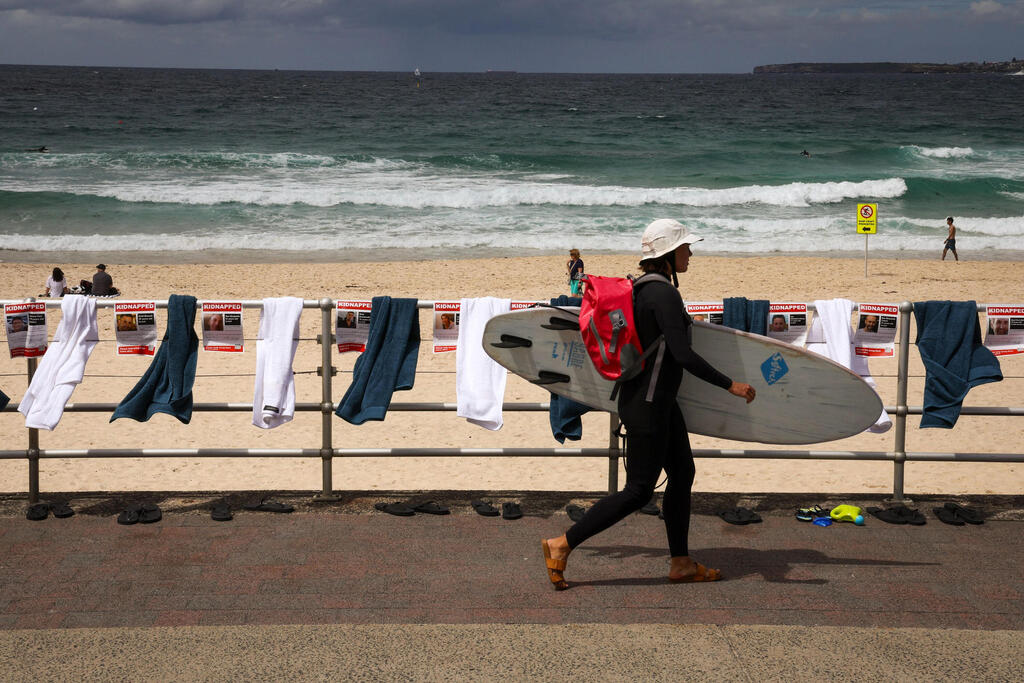 תמונות וחולצות לציון החטופים חטופים בשבי חמאס ב עזה ב  בונדי ביץ' ב סידני  אוסטרליה במיצב שאורגן על ידי הקהילה היהודית המקומית