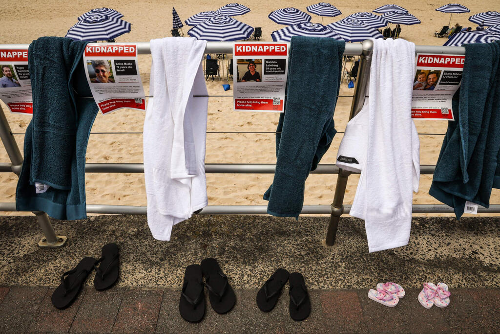 תמונות וחולצות לציון החטופים חטופים בשבי חמאס ב עזה ב  בונדי ביץ' ב סידני  אוסטרליה במיצב שאורגן על ידי הקהילה היהודית המקומית