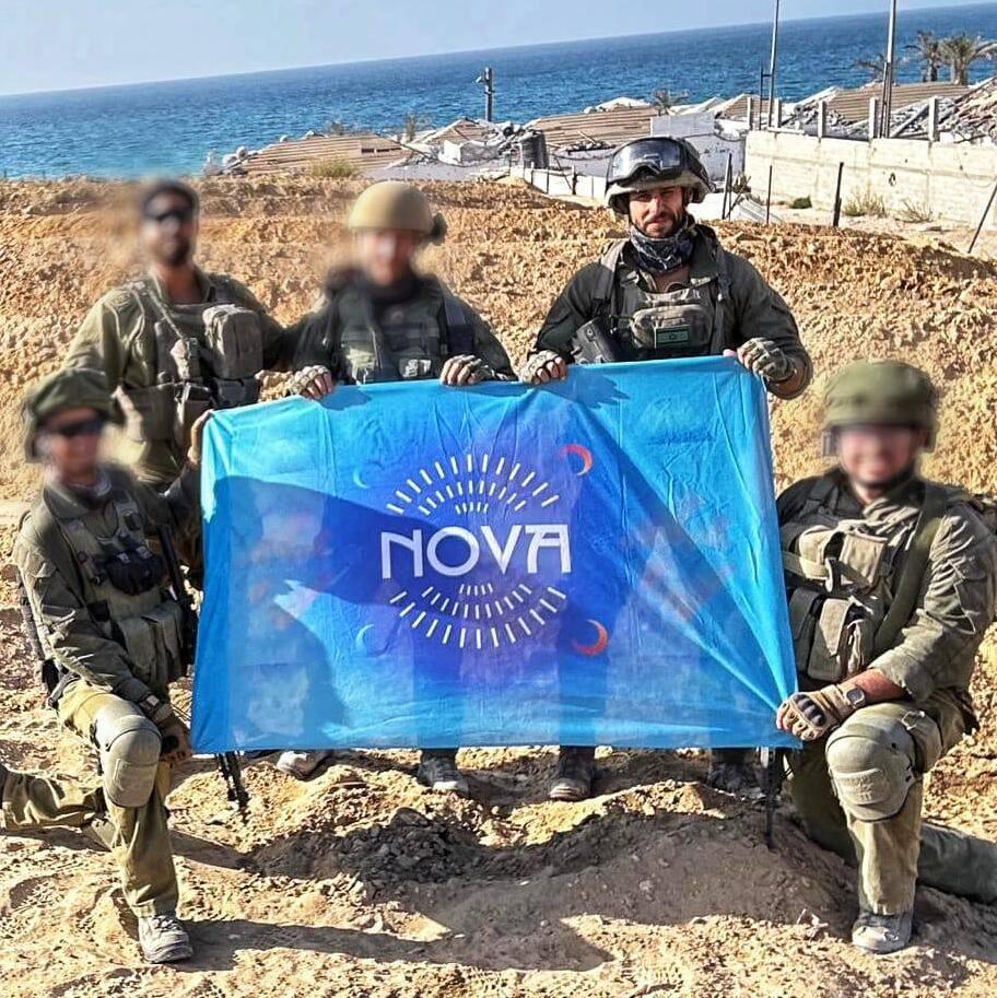 עידן עמדי וחבריו לצוות מניפים את דגל נובה על החוף בעזה