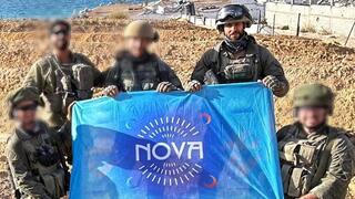 עידן עמדי וחבריו לצוות מניפים את דגל נובה על החוף בעזה