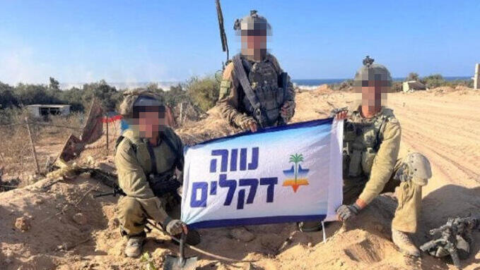 חיילים מחזיקים שלט "נווה דקלים" ככל הנראה בחוף בעזה