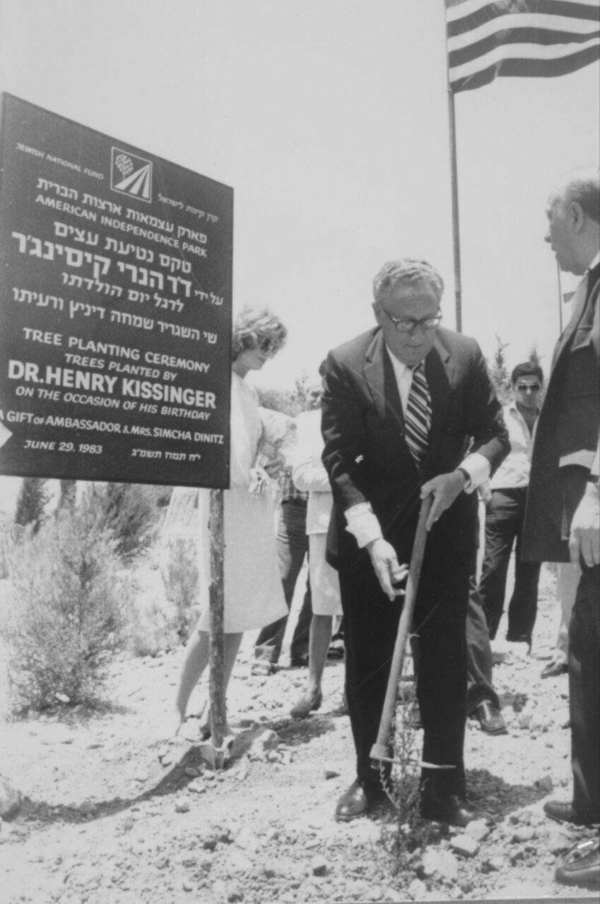 Henry Kissinger plants a tree at the Nes Harim Moshav near Jerusalem at a planting ceremony for his birthday on June 29, 1983.
