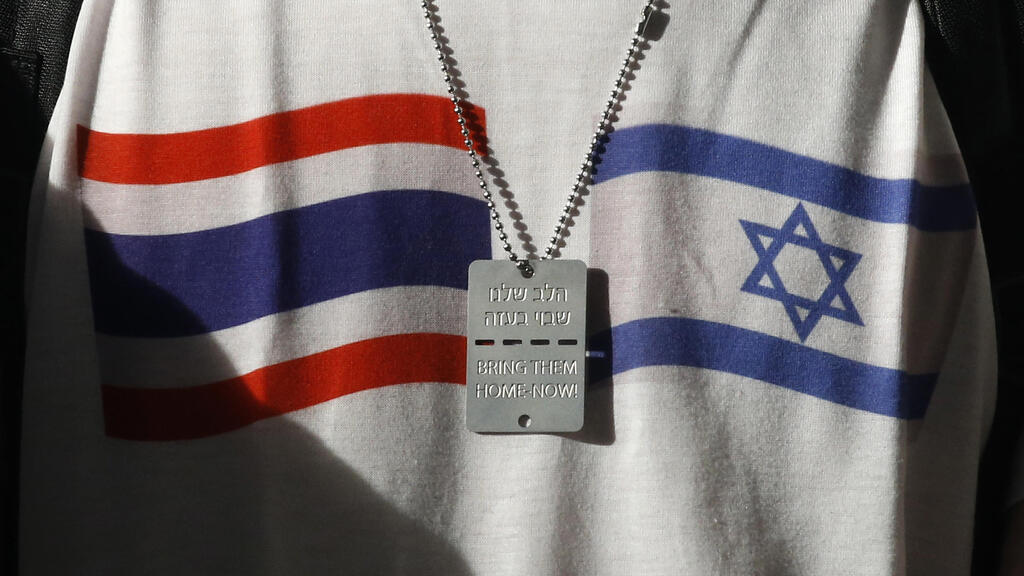 תאילנד חזרת חטופים מ עזה ל בנגקוק חטוף משוחרר שחזר עם חולצה עם דגלי ישראל ותאילנד