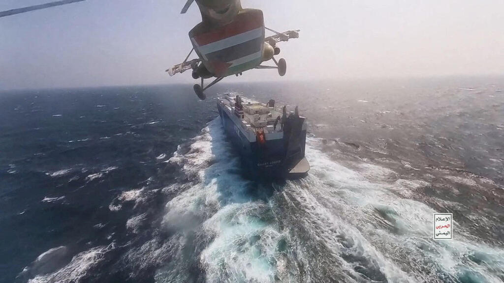 Houthi military helicopter flies over the Galaxy Leader cargo ship in the Red Sea 