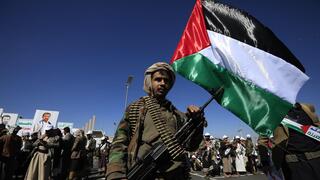 לוחם חות'י צועד עם דגל פלסטין