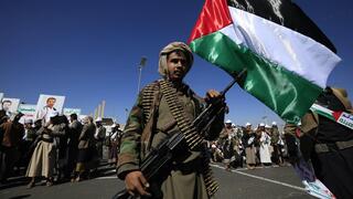 לוחם חות'י צועד עם דגל פלסטין