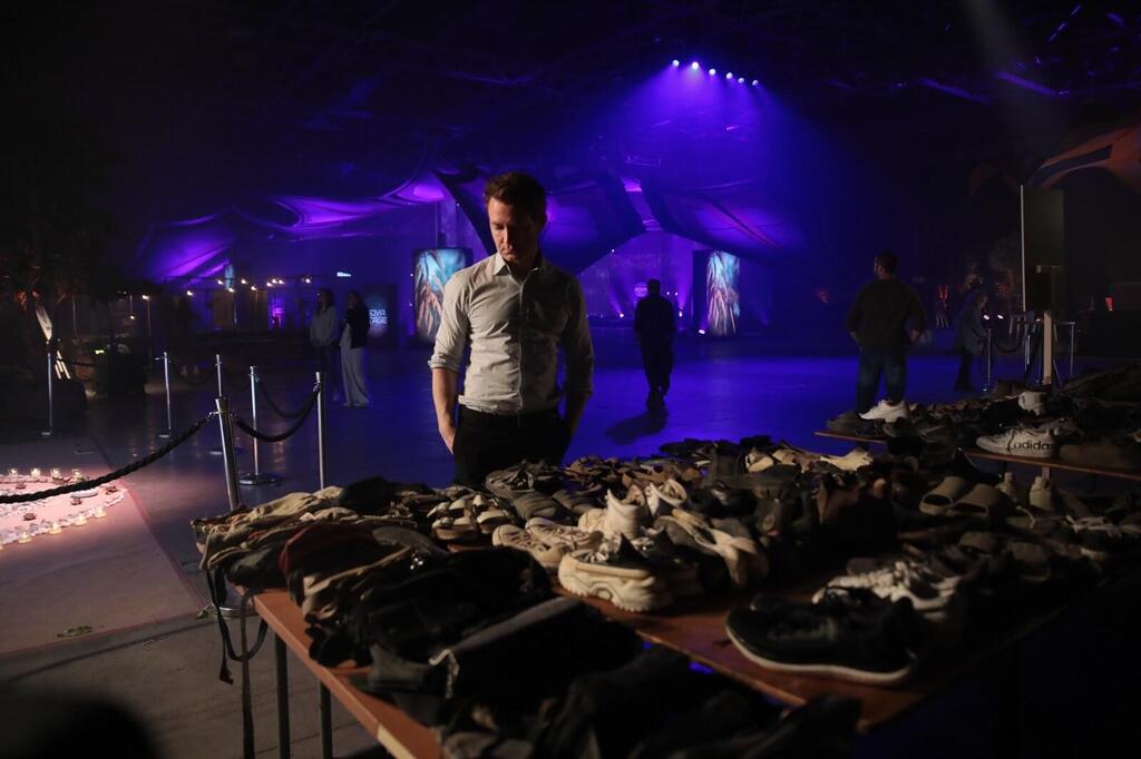 Douglas Murray looks at a table with shoes, purses, and other belongings left behind by festivalgoers who were murdered by Hamas at the Nova Music Festival, at an exhibit at the Tel Aviv Expo center, Dec. 7, 2023. 
