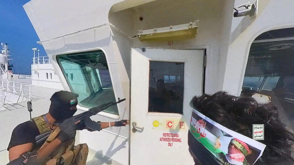 Houthi fighters open the door of the cockpit on the ship's deck in the Red Sea in this photo released November  