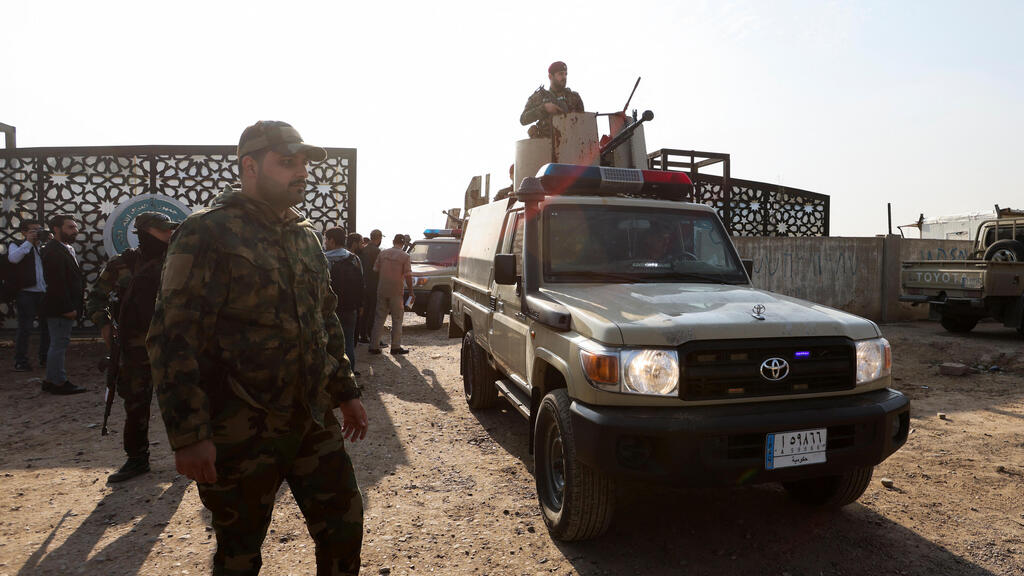 חמושים ב מיליציה מיליציות פרו-איראניות ליד  המטה שלהם ב בגדד עיראק שהופצץ