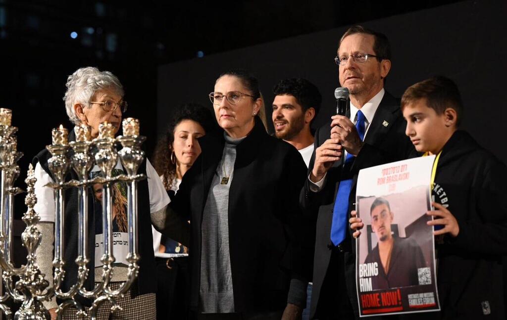 Michal Herzog and President Isaac Herzog light Hanukkah candles with family members of people taken hostage in Gaza, at Hostage Square in Jerusalem 