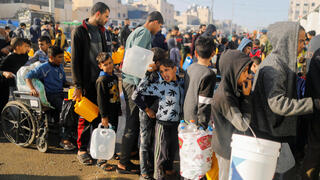 פליטים פלסטינים פליט מחכים עם בקבוקים  בתור ל מים ב רפיח רצועת עזה