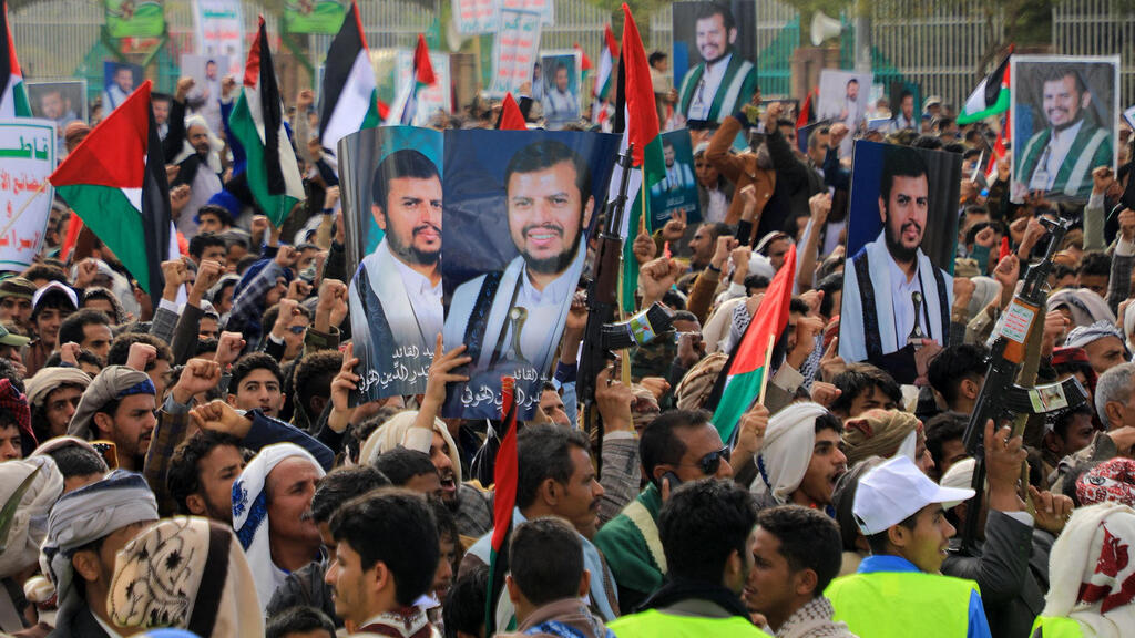 Houthis protest U.S. UK bombing holding pictures of leader Abdul Malik al-Houthi  