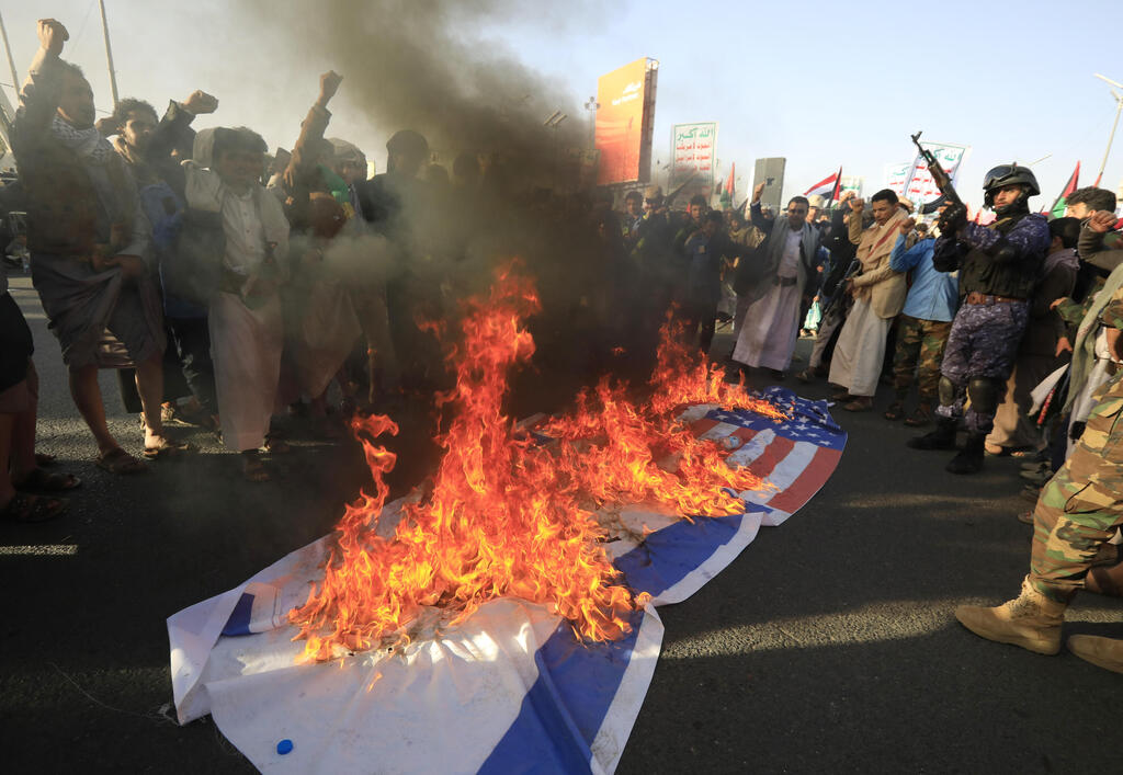 Houthis burn the American and Israeli flags in protest of the U.S. attack on Houthi targets 